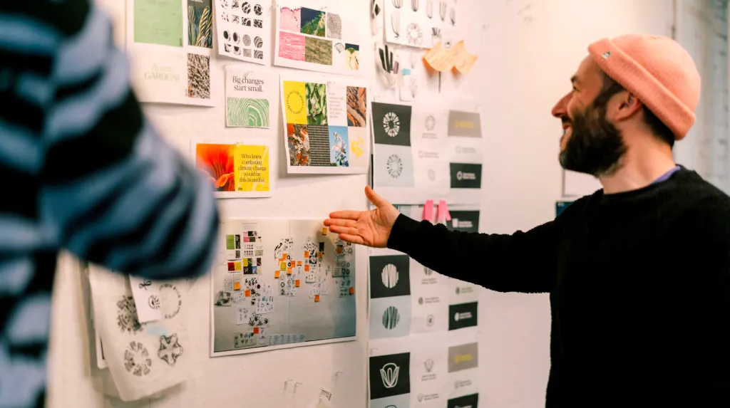 designer and creative director building a mood-board together at the pin-up wall in the office