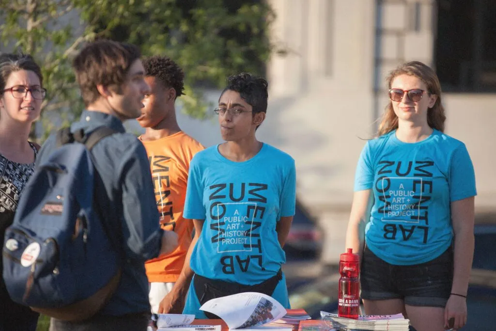 volunteers working at exhibition wearing colorful graphic logo tshirts