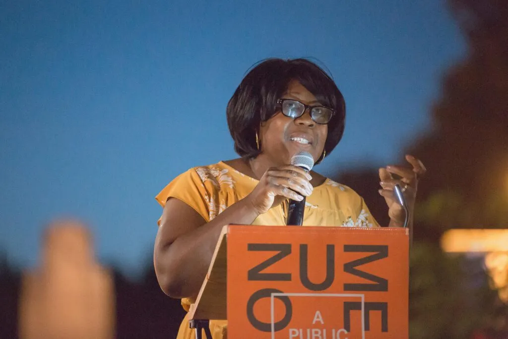 African American woman speaking at branded podium