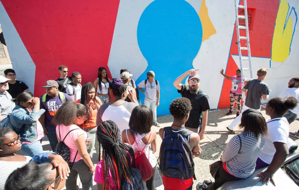 Artist speaking in front of Philadelphia mural