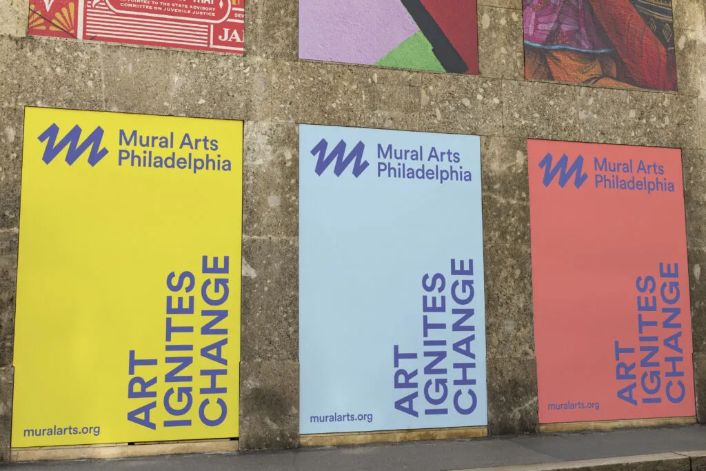 Colorful billboards featuring Mural Arts Philadelphia logo and tagline