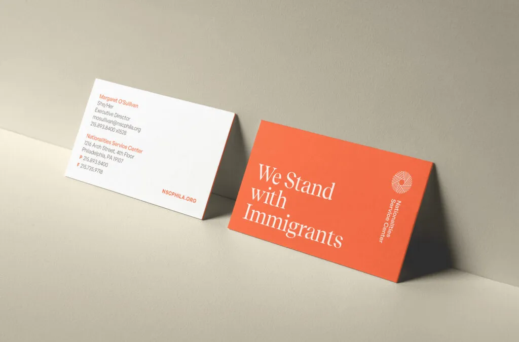 Orange and white business cards mockup with large serif tagline and vertical logo