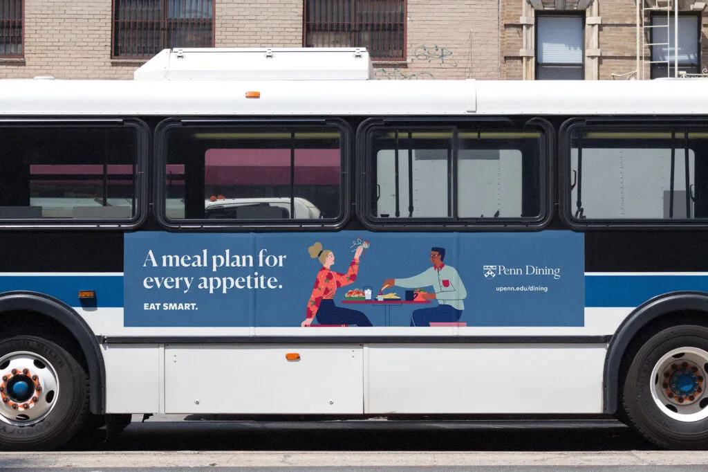 Clean and bold bus campaign for university dining program with illustration of two students eating together in dining hall