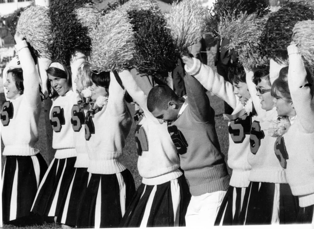 black and white vintage photograph of cheerleaders at a college football game