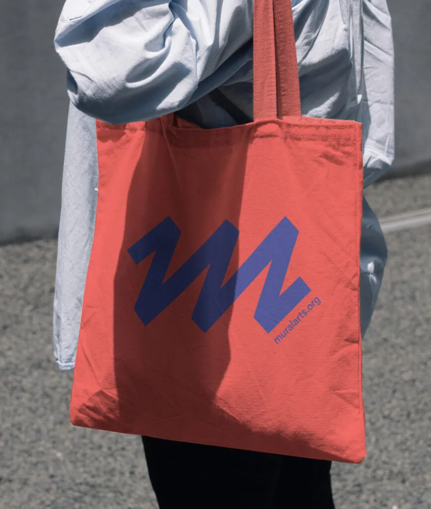 Red tote bag featuring Mural Arts Philadelphia logo by J2