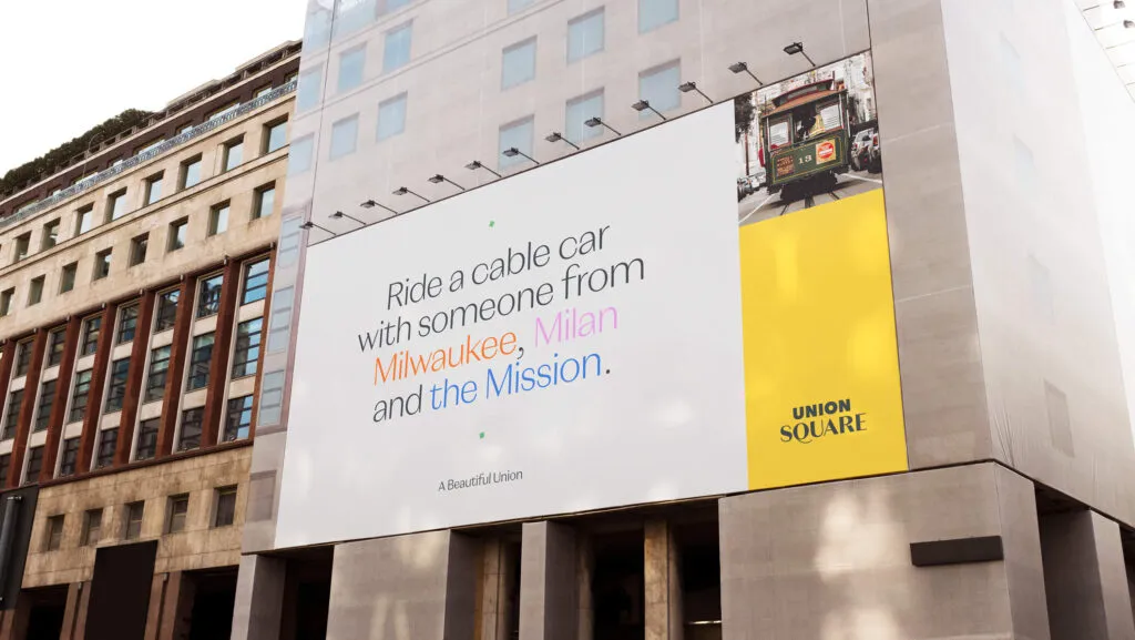 illuminated billboard with multicolored typography, Union Square branding by J2