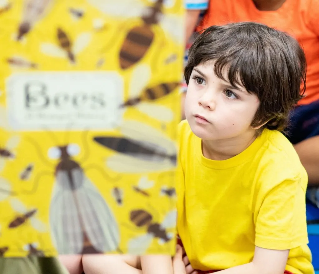 Young school student listening to a book read aloud during story time