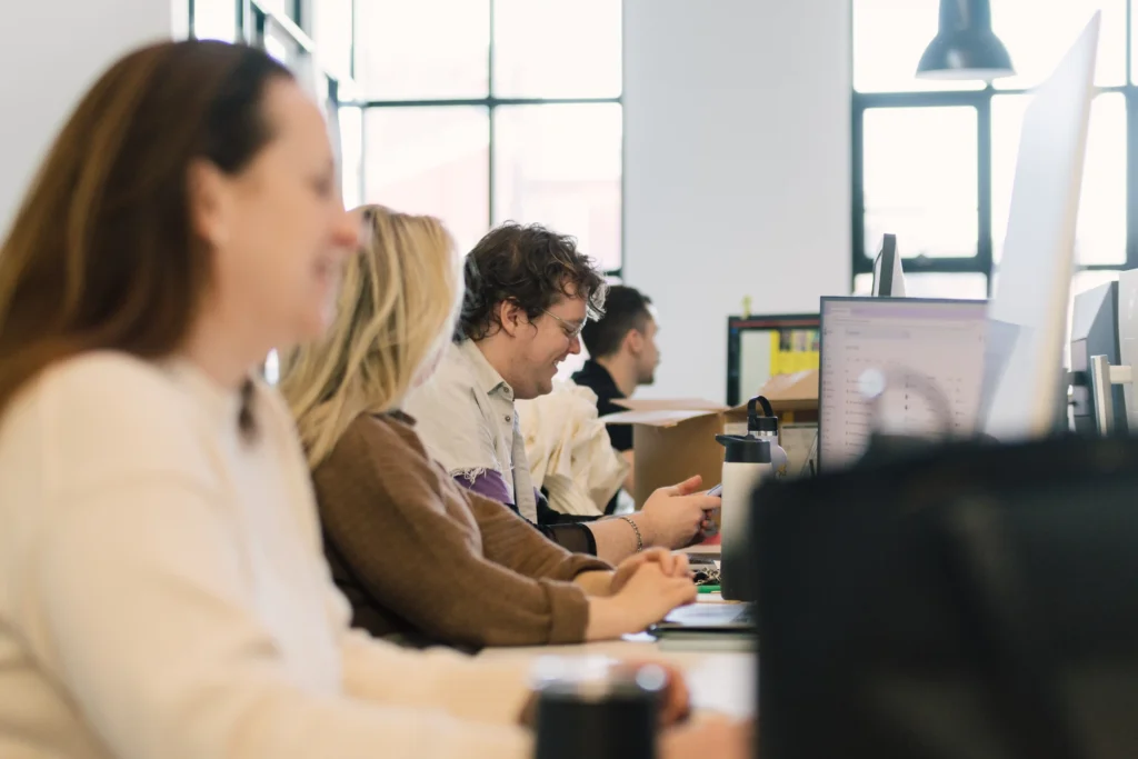 Account Managers and Designers at work stations in modern office