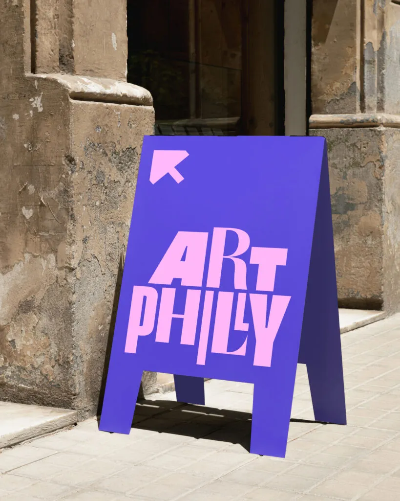 A-frame directions sign pointing to ArtPhilly arts festival. Branding by J2.