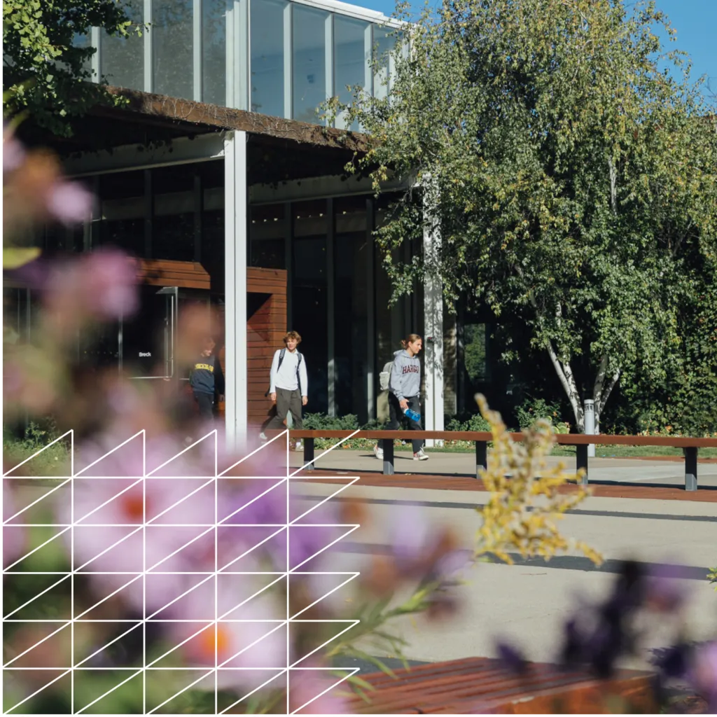 Two students walking on college preparatory school campus with colorful landscaping