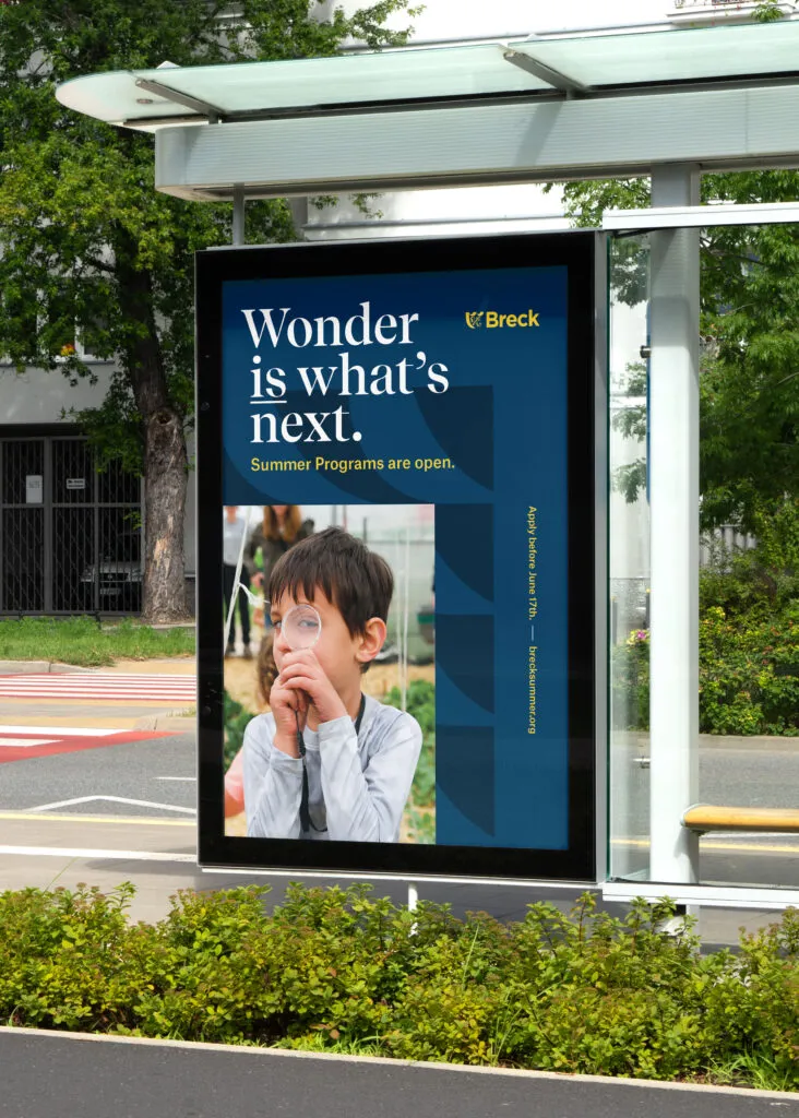 Bus stop advertising using typography and photo of student looking through a magnifying glass. Branding for Breck School by J2.