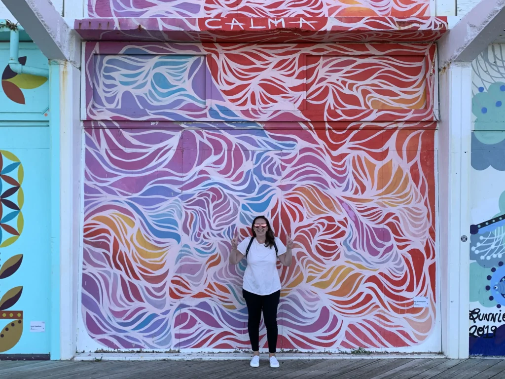 Jess D'Elia, Account Director at J2 standing in front of a huge mural