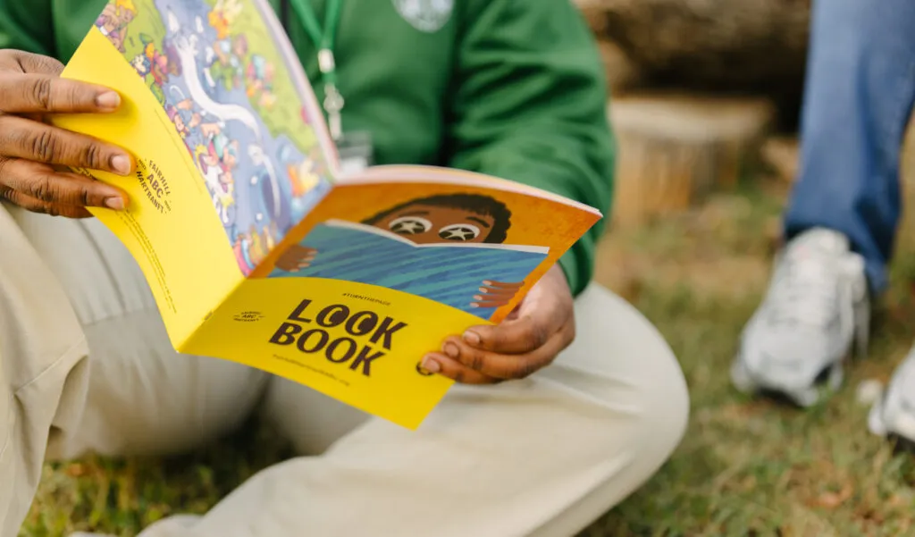 Teen boy reading brand look book. Literacy Rich Initiative brand by J2.