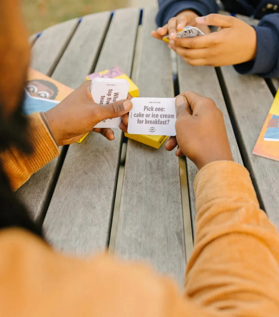 Man and girl playing with literacy cards and laughing. Literacy Rich Initiative brand by J2.