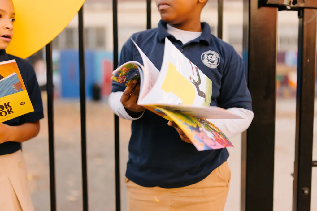 Image of boy with brand collateral. Literacy Rich Initiative brand by J2.