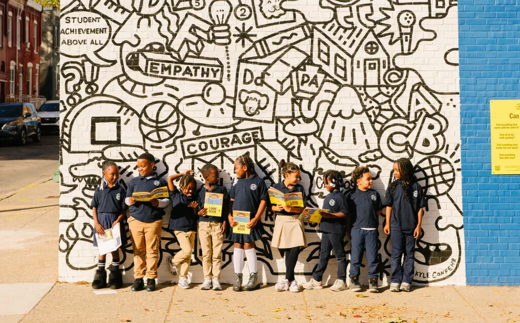 School children posing with I spy mural. Literacy Rich Initiative brand by J2.