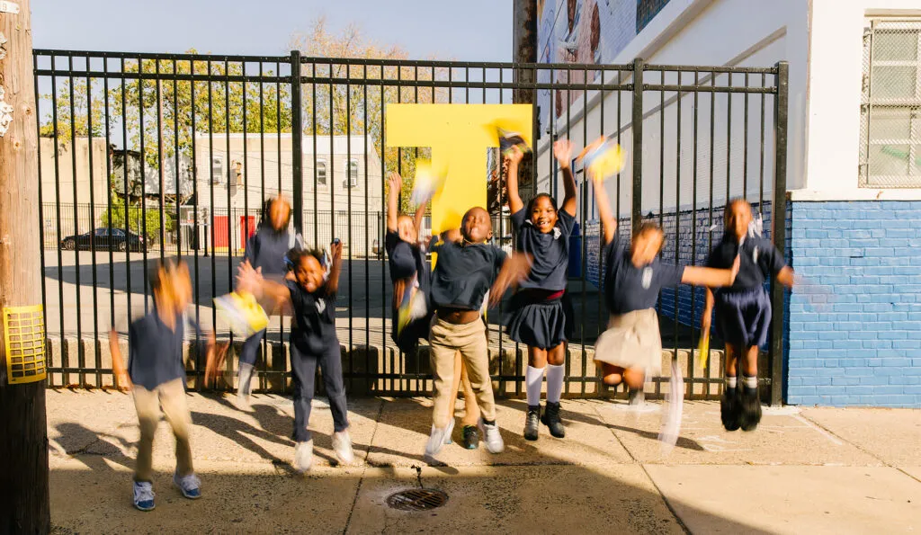 Kids jumping with excitement at literacy installation. Literacy Rich Initiative brand by J2.