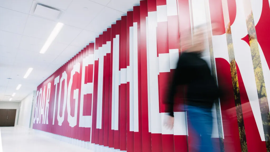 Wide shot of lenticular wall at an angle. The wall reads 