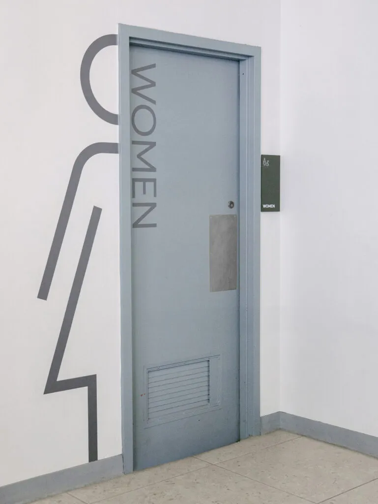 women's room signage with large iconic wall graphic